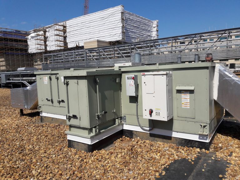 Several pieces of HVAC equipment with ductwork and switchgear mounted on the roof of the hospital