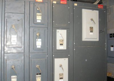 Large metal enclosure peppered with multiple switchgears and equipment information tags in the mechanical room