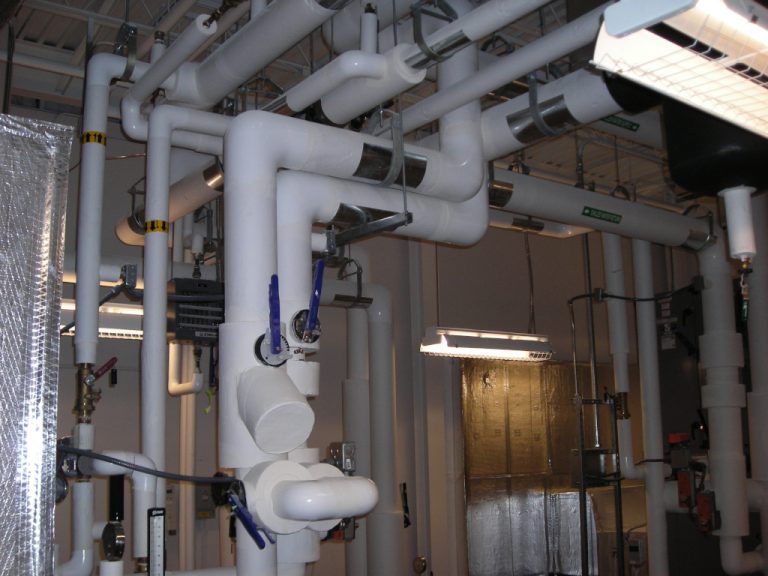 Various sizes of flow valves and white pvc piping carrying chilled water to some of the equipment