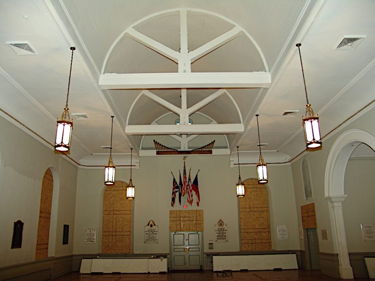 Arched trusses and classical ceiling mounted pendant lights adorn the empty sanctuary during construction