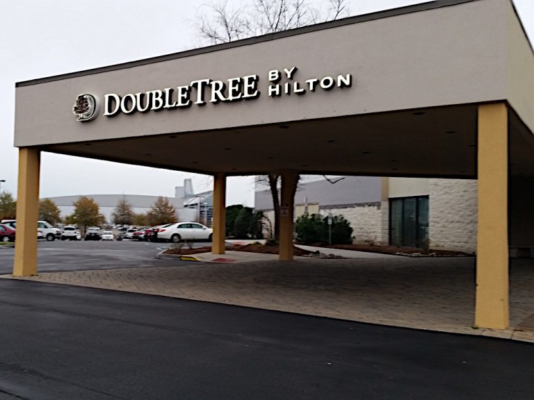 The Doubletree Hotel by Hilton sign on the face of the portico where vehicles park to unload in front of the building