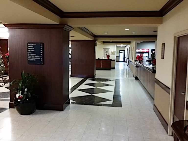 Side view of the Doubletree Hotels' stylized lobby complete with black and white checkered flooring and a large wooden front desk located alongside a small vending area