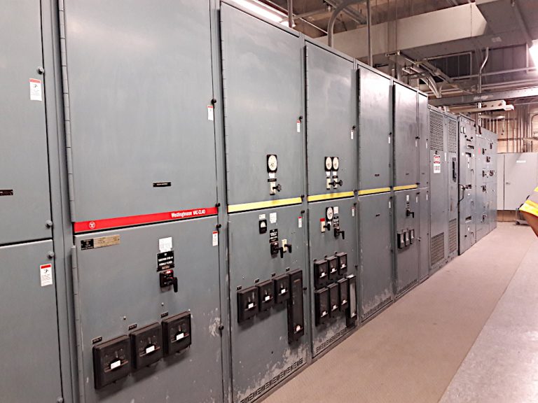 Long row of industrial size metal transfer switches and switchgear at the control center for managing the midtown tunnel in Portsmouth Virginia