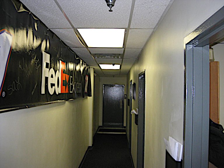 Interior hallway of the warehouse office space with an autographed FedEx banner hanging on the left and open doorways to the offices on the right