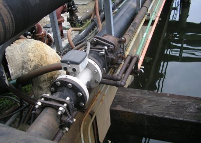 Industrial piping and other pier utilities shown together alongside the water