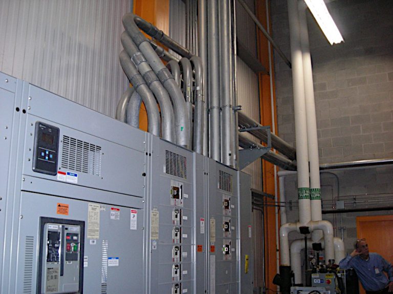Industrial size transfer switch cabinet, conduits and other electrical equipment inside the mechanical room of the Stihl building