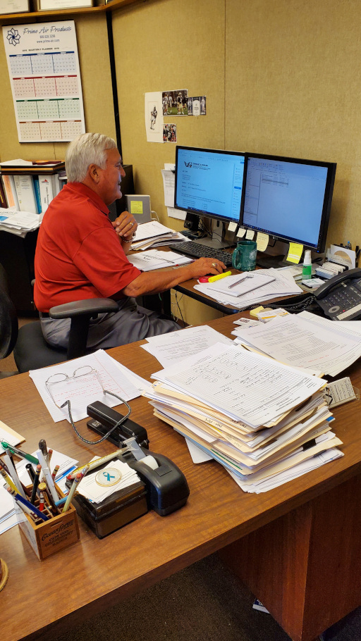 Male professional employee A Vansant & Gusler engineering professional sitting at his desk smiling while using his computer